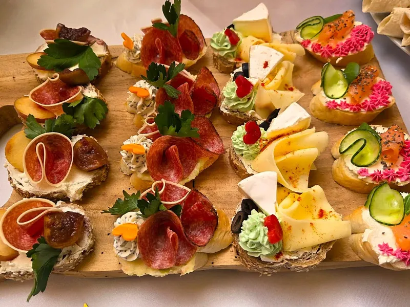 Kanapky s uzeninami a sýry na dřevěném prkně